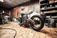 A vintage motorcycle under repair in a cluttered workshop, showcasing DIY craftsmanship.